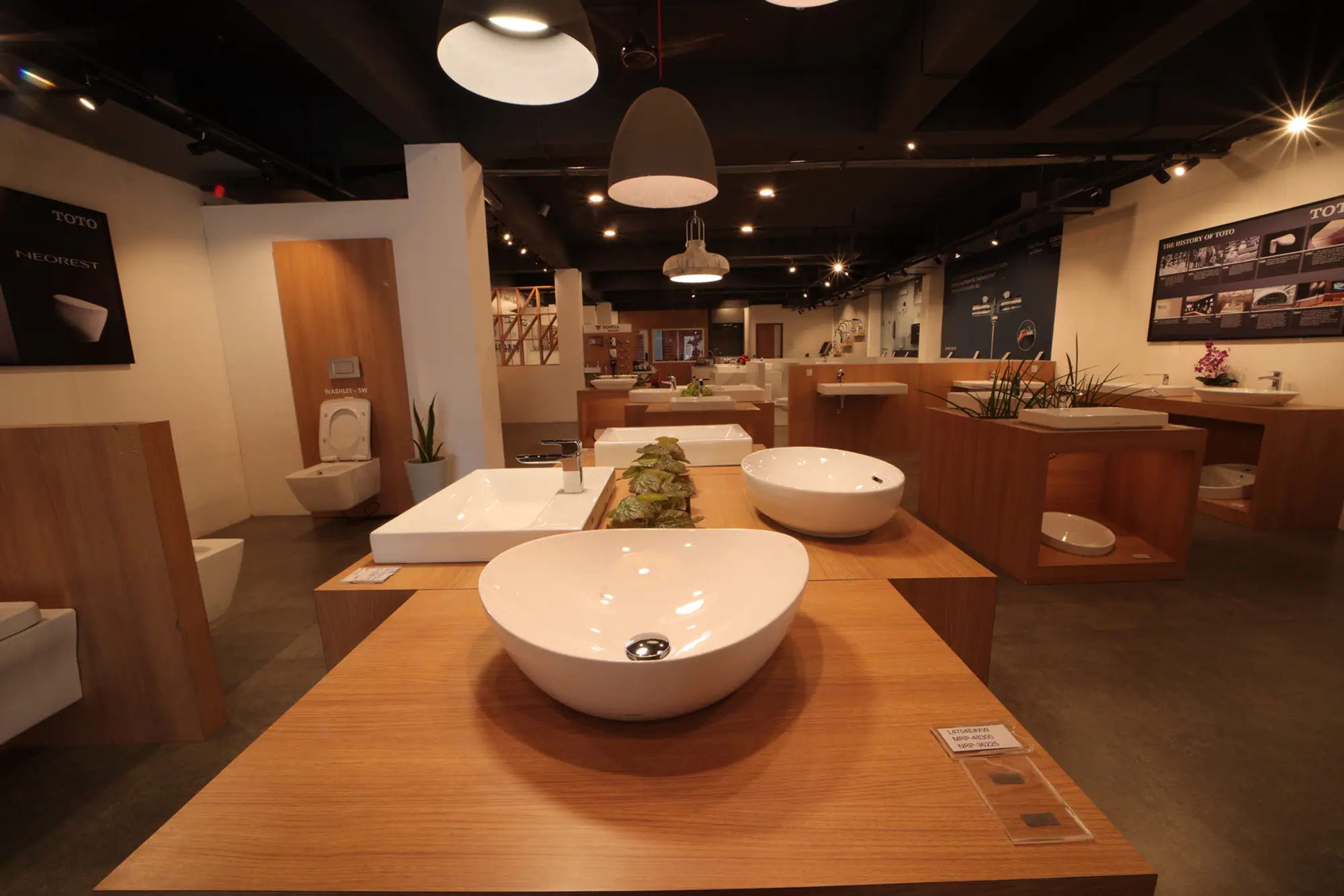 Inside the Venus showroom, Attingal — sanitaryware displayed on oak plinths beneath gallery lighting.